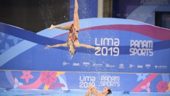 Artistic swimmer performs a flip in the air