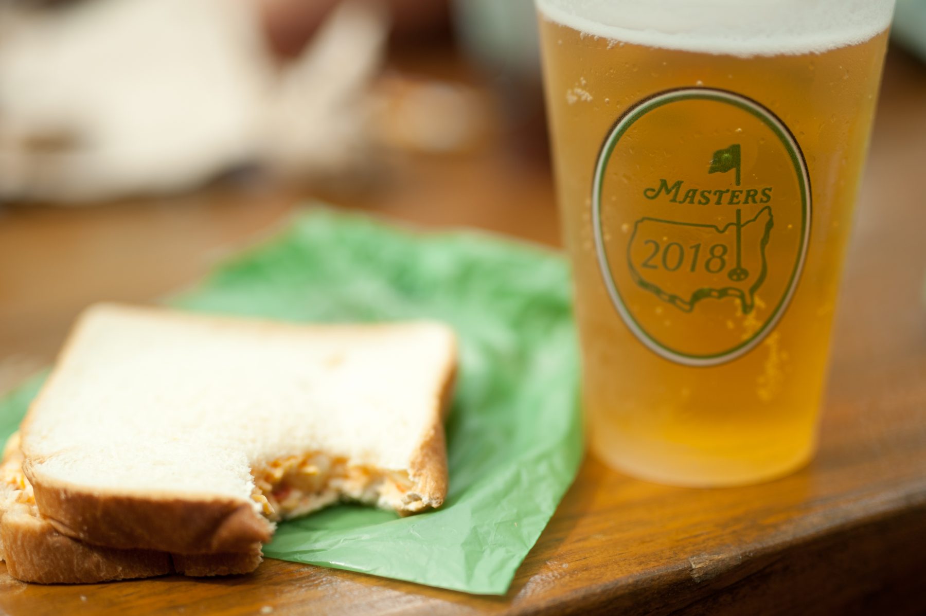 Sandwich with a bite out of it with a cold beer to the right