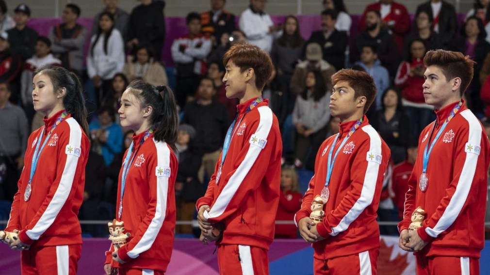 Canada's taekwondo team stands with medals