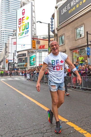 Vincent Lavoie walks down Yonge Street during the 2018 Toronto Pride Parade.