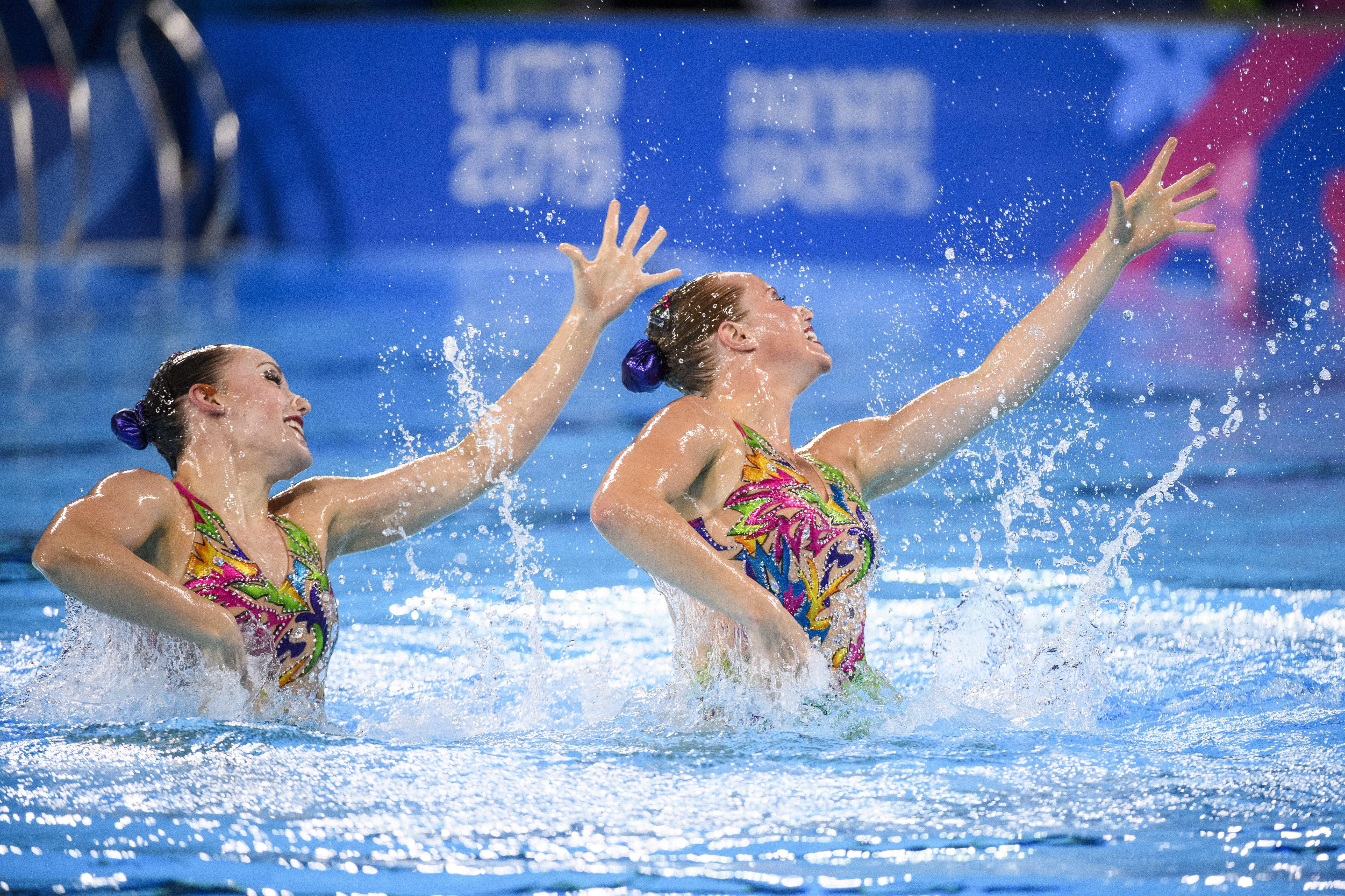 Claudia Holzner and Jacqueline Simoneau leaping out of the water