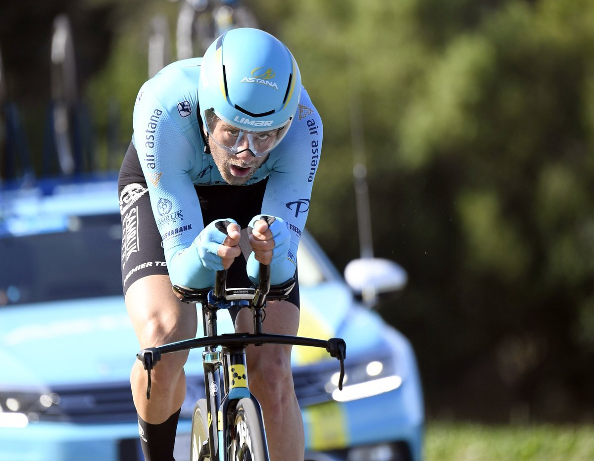 Man rides bike with car following behind