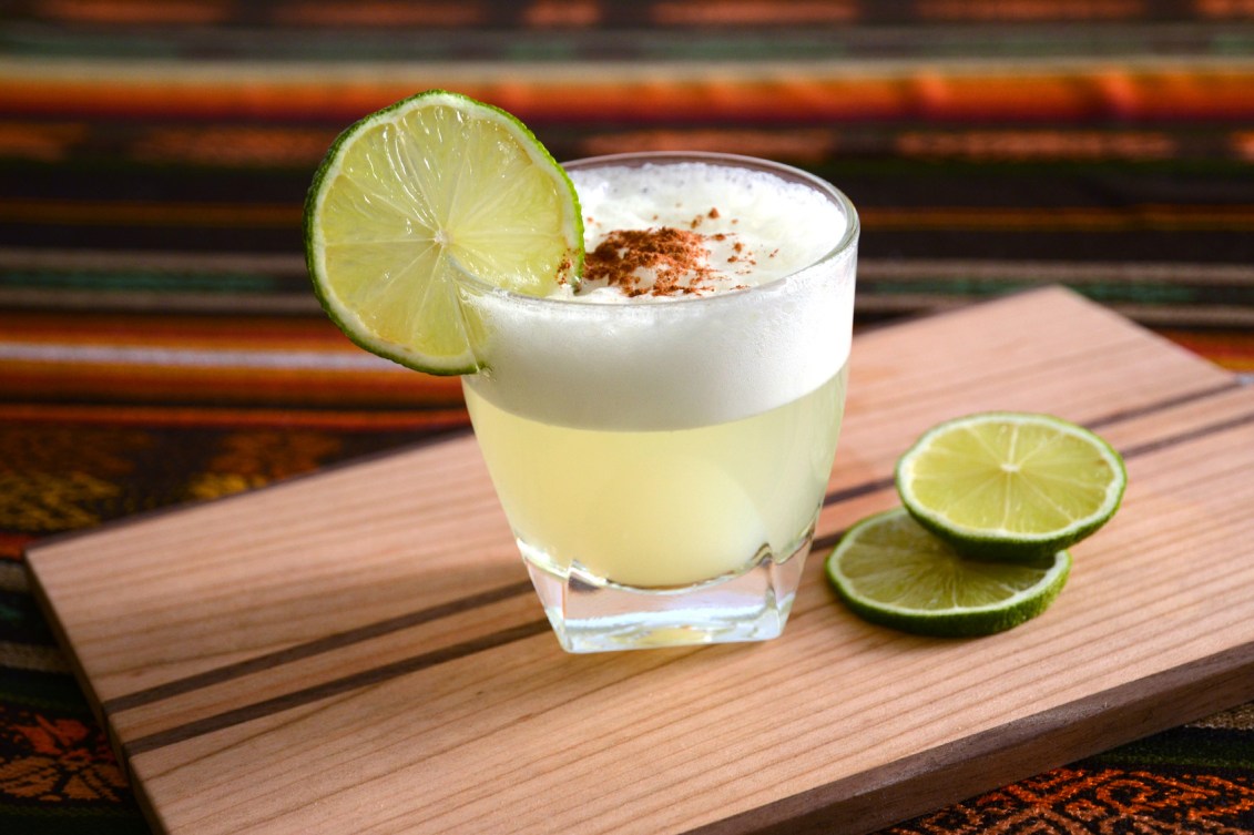 A photo of a pisco sour in Peru, garnished with a lime.