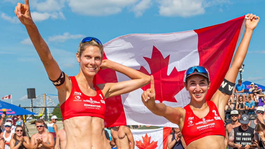 Sarah Pavan and Melissa Humana-Paredes hold the Canadian flag over their heads