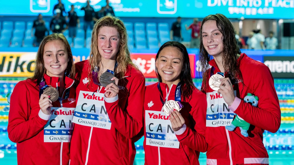 Four swimmers posing with medals