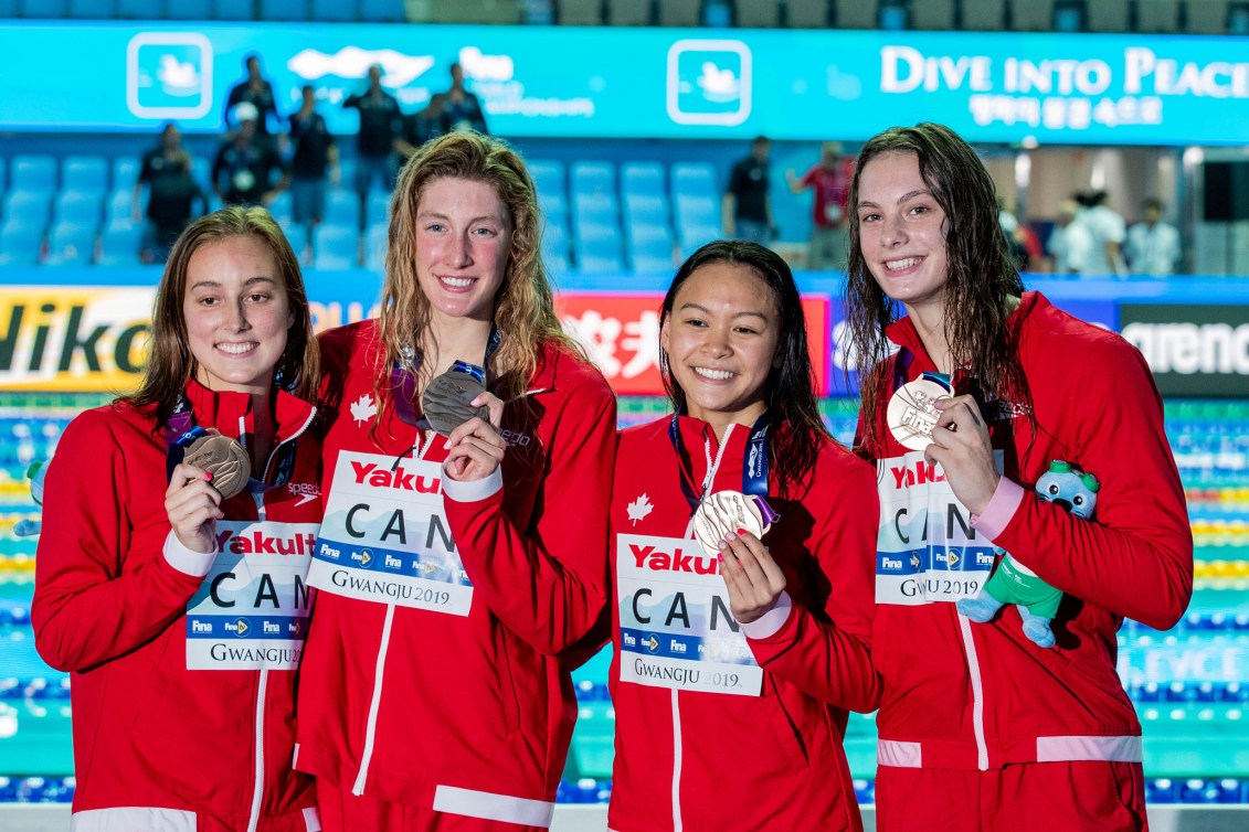 Four swimmers posing with medals