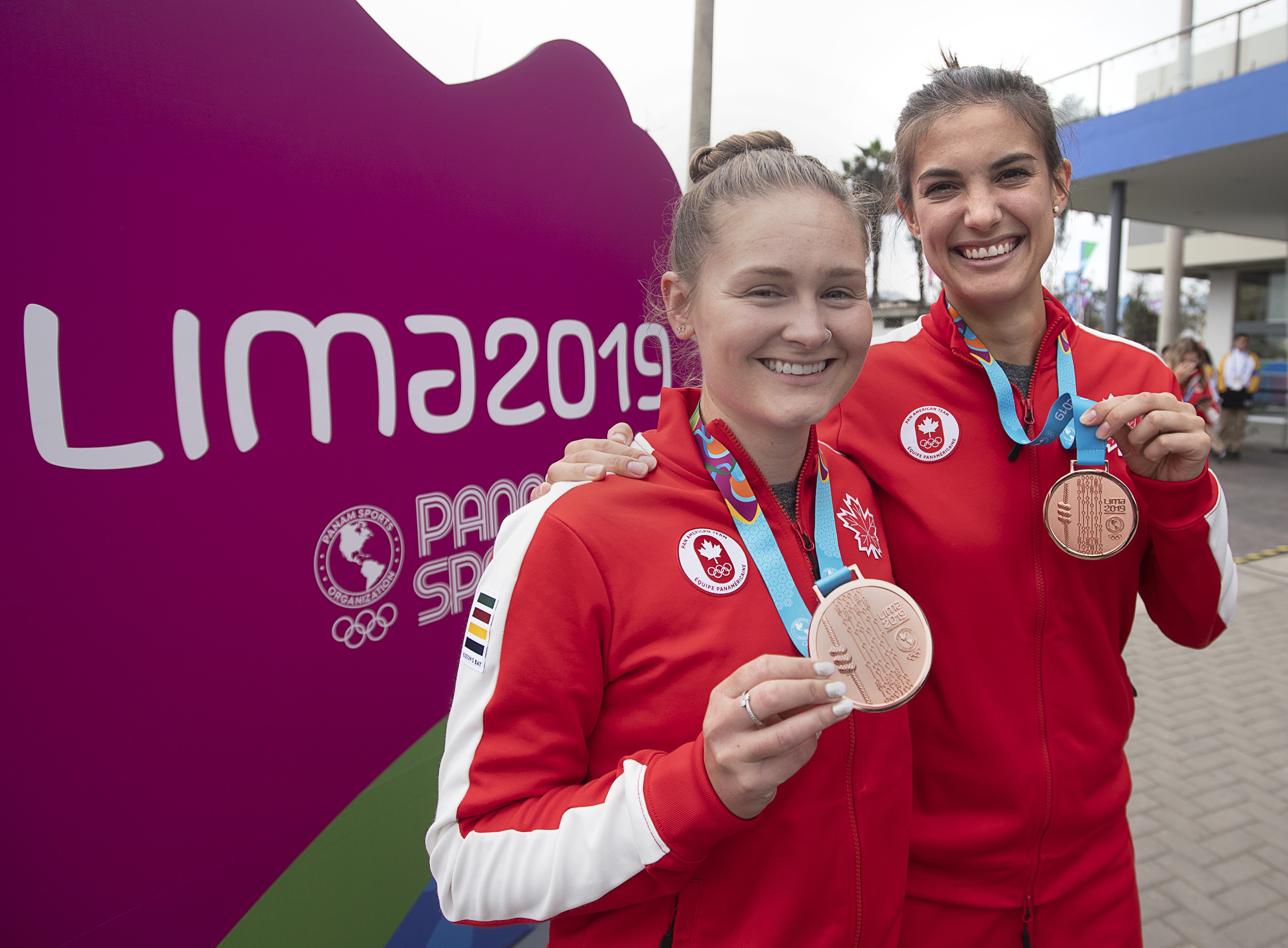 Squash athletes Samantha Cornett, right, and Hollie Naughton display their bronze medals