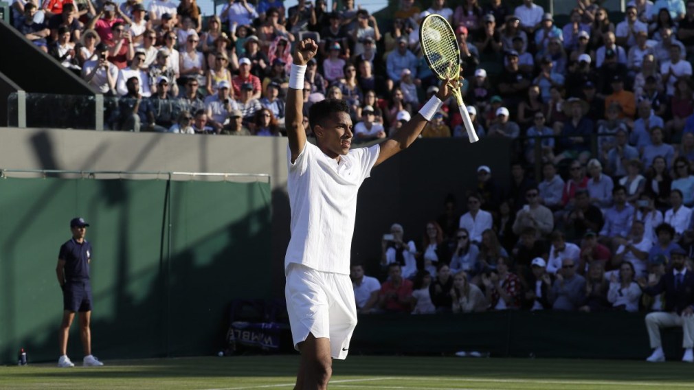 Felix Auger-Aliassime celebrates win with arms raised above head