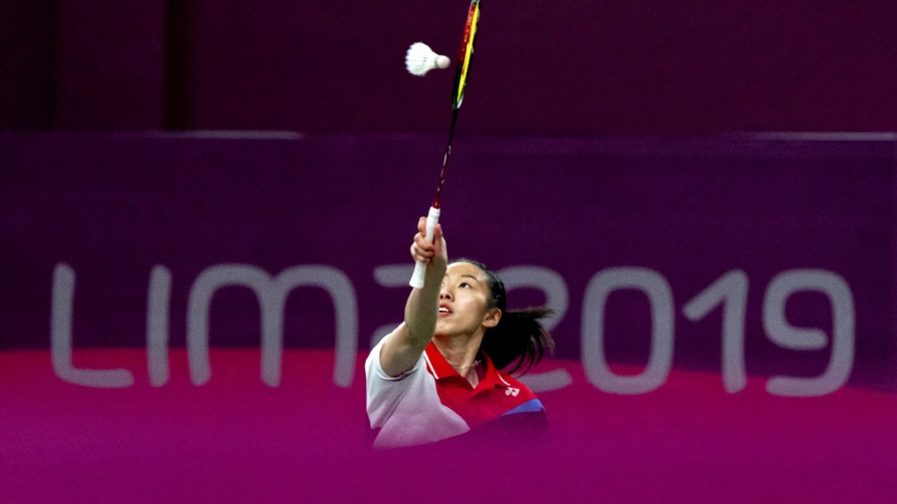 badminton player reaches for the birdie