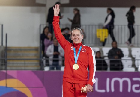 athlete raises her hand to acknowledge the crowd