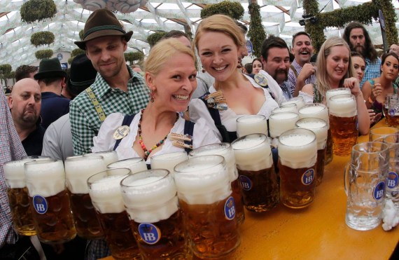 Two Oktoberfest waitresses pose with a dozen beer steins