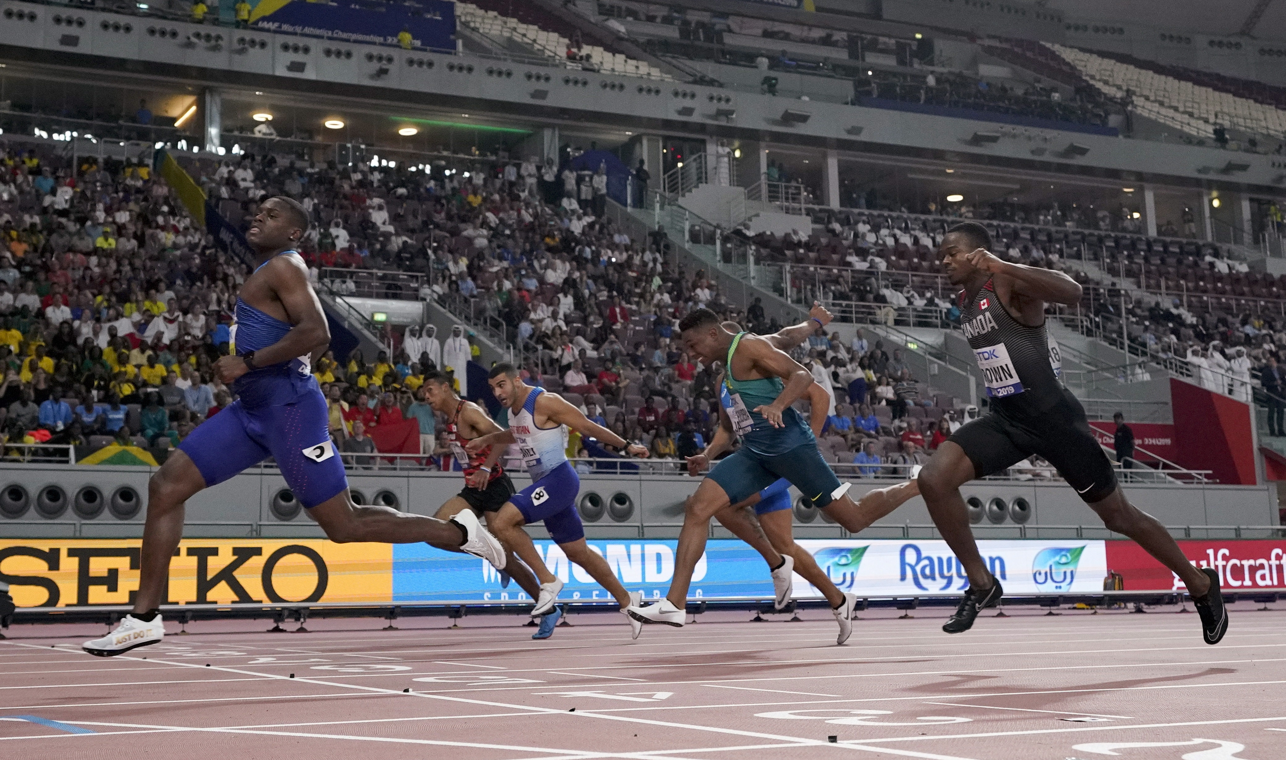 Christian Coleman, of the United States, crosses the line ahead of Aaron Brown, of Canada, and Adam Gemili, of Great Britain