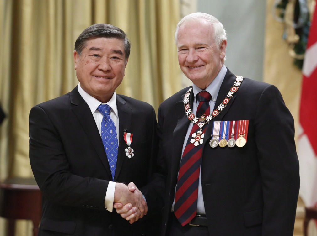 Hiroshi Nakamura (left) shakes hands with Governor General David Johnston during the Order of Canada ceremony.