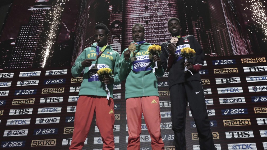 Muktar Edris (centre), Selemon Barega (left), and Mohammed Ahmed (right) receive their medals.
