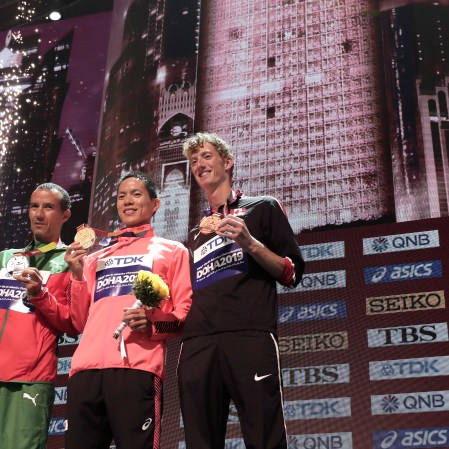 Qatar Athletics Worlds Evan Dunfee stands on the podium with his bronze medal alongside the first and second place winner.