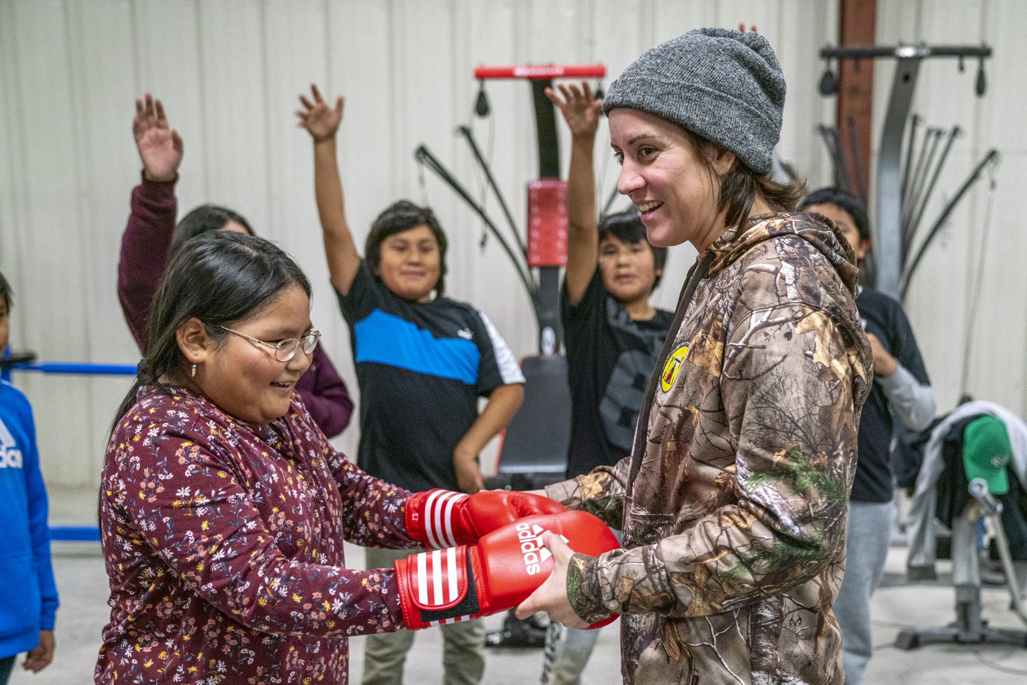 Mary Spencer shares her boxing gloves with a young student