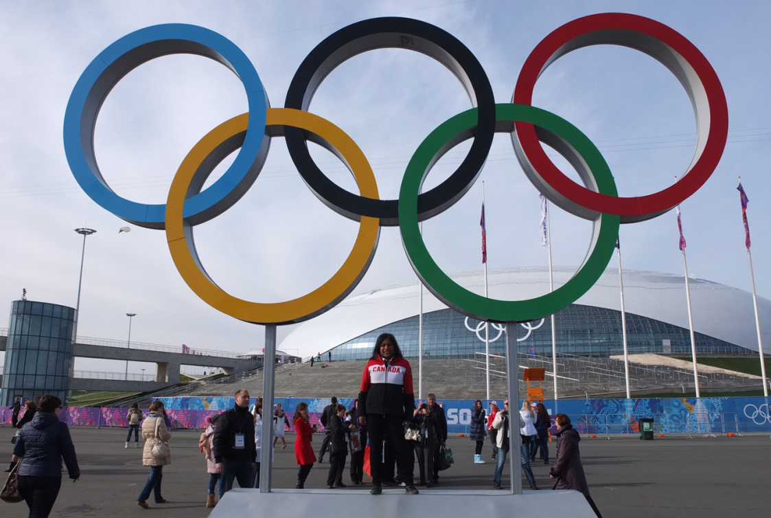 Team Canada volunteer Shanti poses in front of the Olympic Rings at the Sochi 2014 Olympic Park.