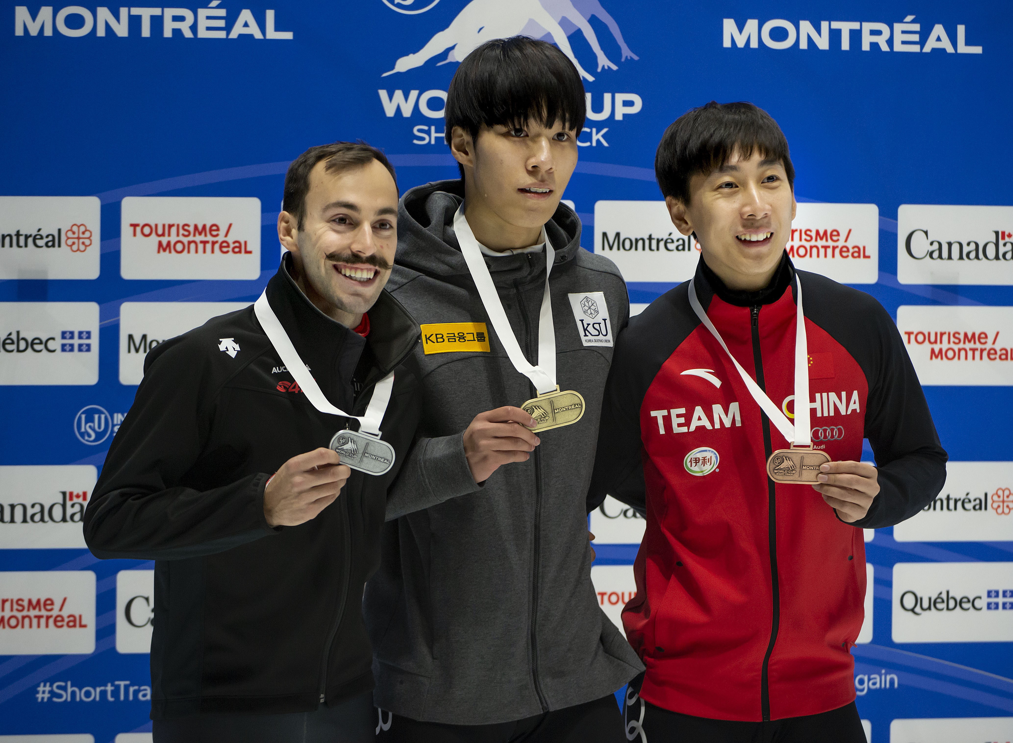 steven dubois on the podium posing with his silver medal alongside the gold and bronze medal