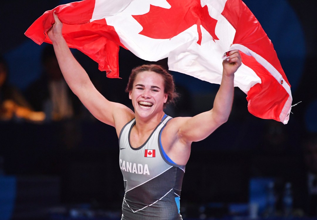 Linda Morais waves the Canadian flag above her head after winning her match.