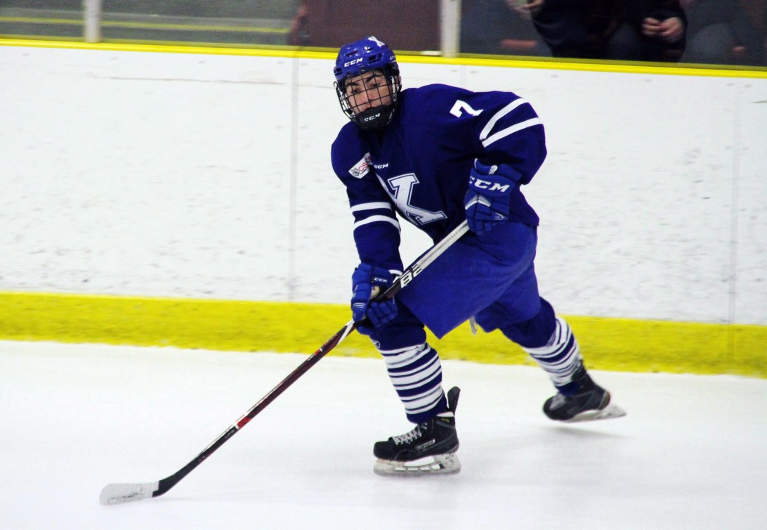 Hockey player skates with puck