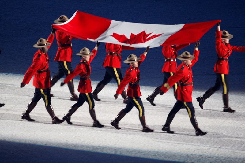 The Royal Canadian Mounted Police raise the flag high carrying it into the opening ceremonies of the Vancouver 2010 Olympics. 