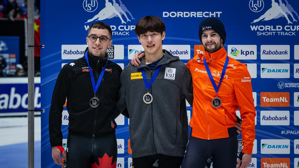 Short track speed skating medallists stand on the podium after competing