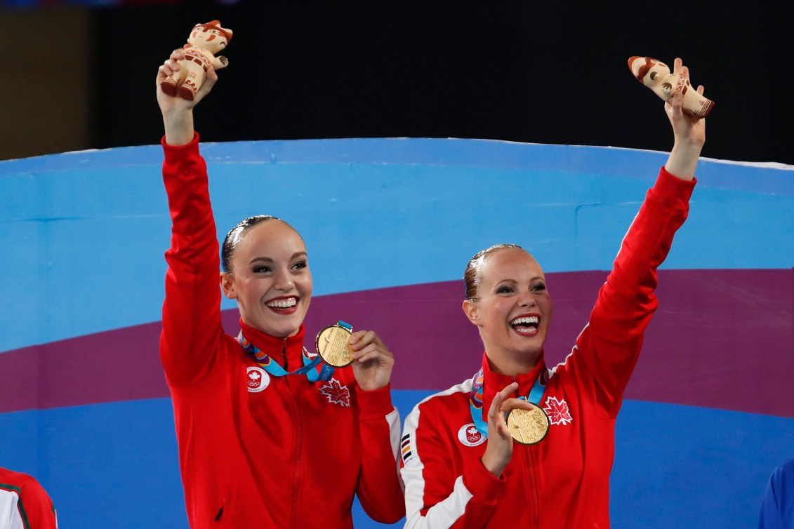 Jacqueline Simoneau, right, and Claudia Holzner, of Canada, celebrates after receiving their gold medals in the artistic swimming duet free routine finals at the Pan American Games in Lima, Peru, Wednesday, July 31, 2019.