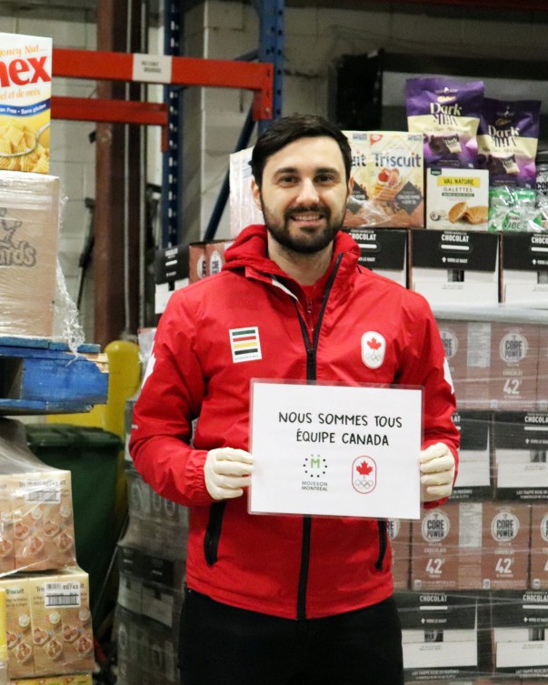 Joseph Polossifakis holds up a "Nous Sommes Équipe Canada" sign.