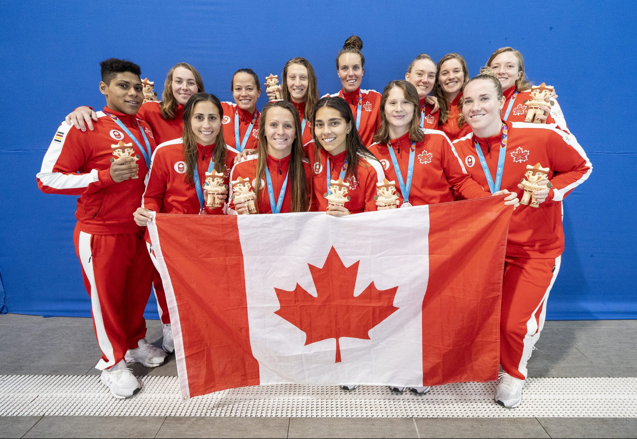 Canada's women's water polo team posed with the Canadian flag