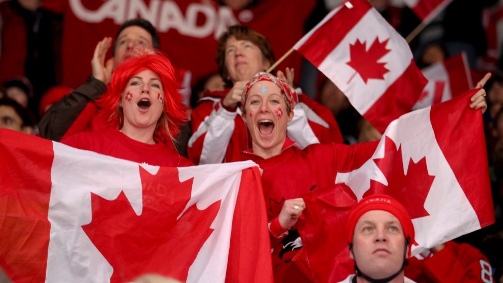Two fans with Canadian flags cheering