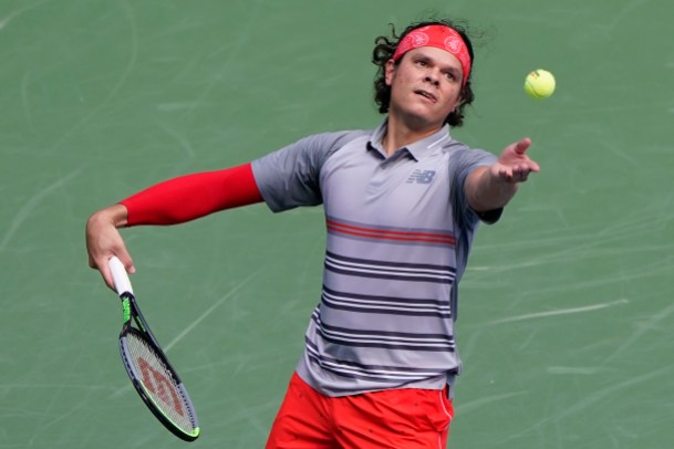 Milos Raonic Milos throws the ball in the air to serve it.