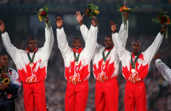 Donovan Bailey, Bruny Surin, Glenroy Gilbert and Robert Esmie raise their hands as they celebrate gold.