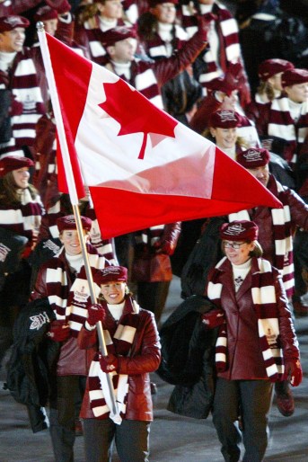 Catriona Le May Doan carries the Canadian flag in front of Team Canada