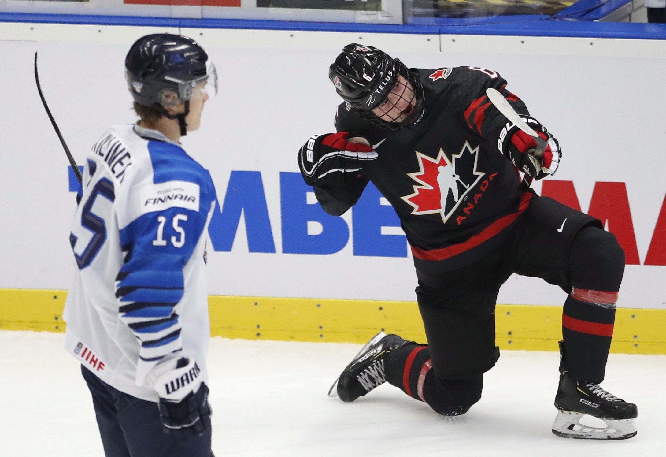 Finland's Lenni Killinen, left, skates past as Canada's Jamie Drysdale, right, celebrates after scoring his sides third goal during the U20 Ice Hockey Worlds semifinal match between Finland and Canada in Ostrava, Czech Republic, Saturday, Jan. 4, 2020. (AP Photo/Petr David Josek)