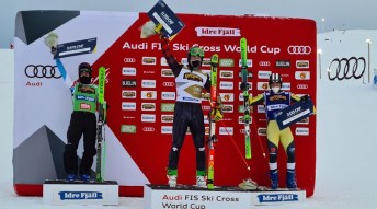 Reece Howden stands on the podium at the Ski Cross World Cup after winning gold