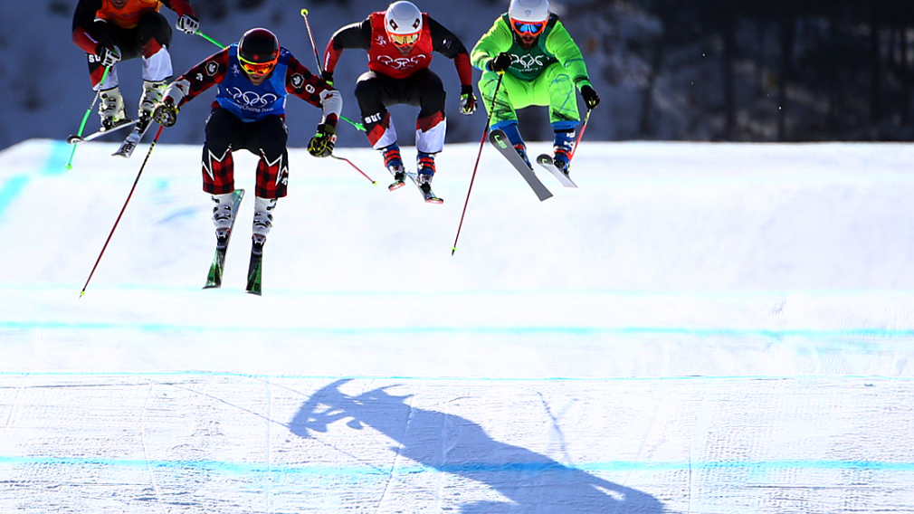 Four skiers up in the air while on a jump racing in ski cross at the PyeongChang 2018 Olympic Winter Games.