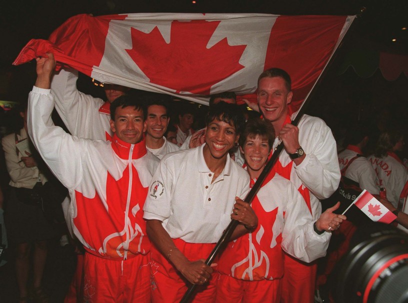 Charmaine Crooks of Vancouver, B.C. the flag bearer for Canada's Olympic team celebrates with teammates (left to right) Toronto race walker Janice McCaffery and Brampton, Ont. swimmer Stephen Clarke. (CP PHOTO) 1996 (stf-Andrew Vaughan)