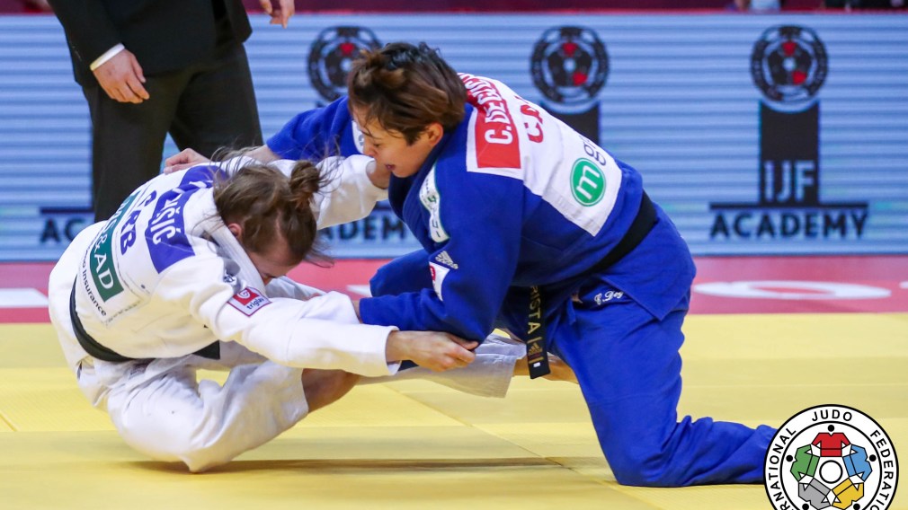 Christa Deguchi (in blue) takes down Serbia's Marica Perisic during a judo match.