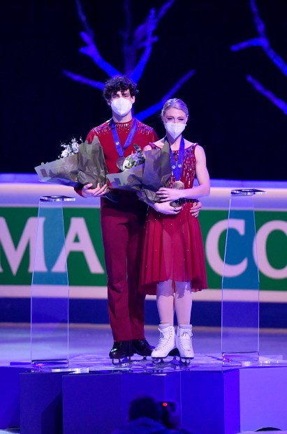 Two figure skaters stand on the podium