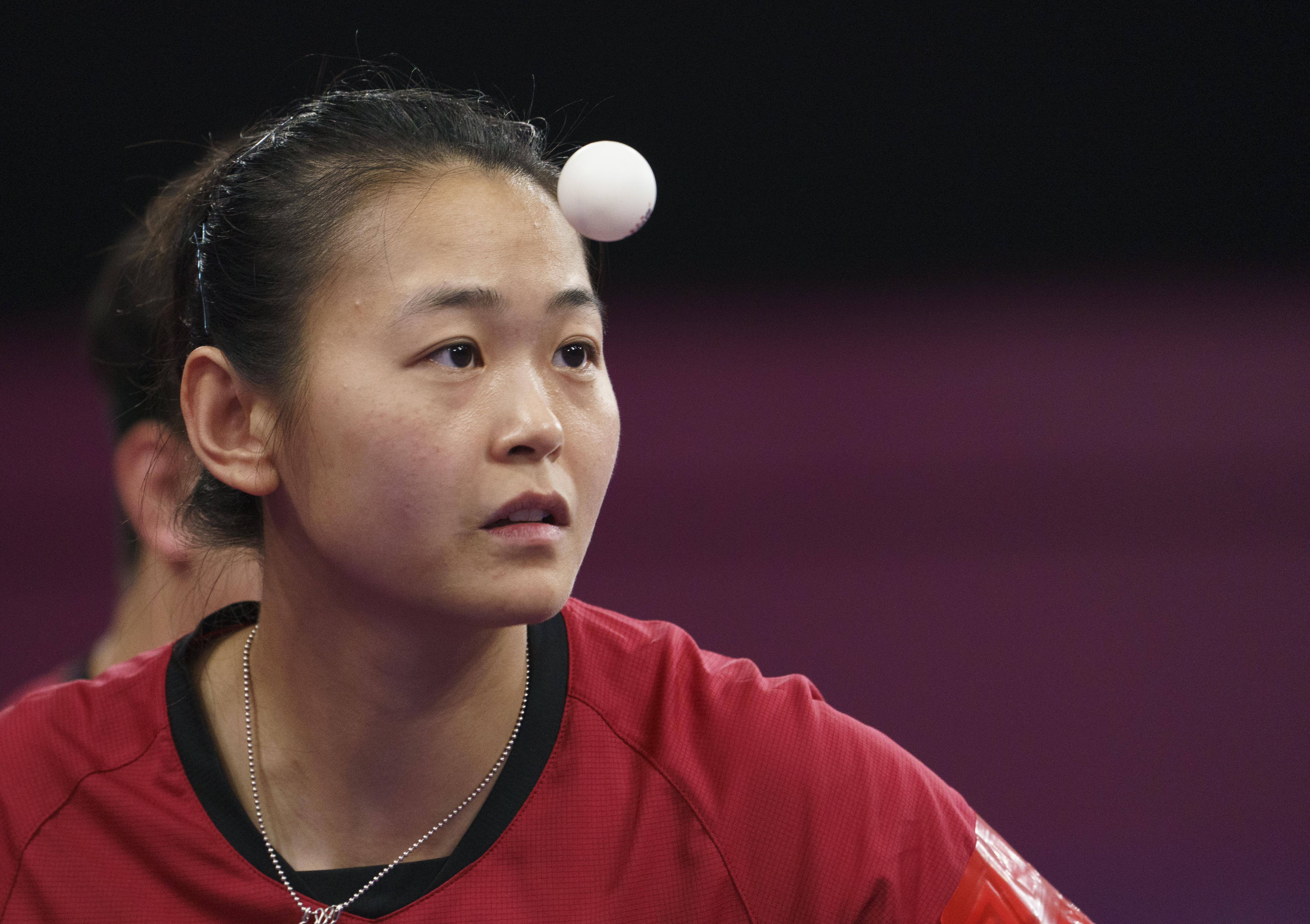 Table tennis ball floats in front of female player