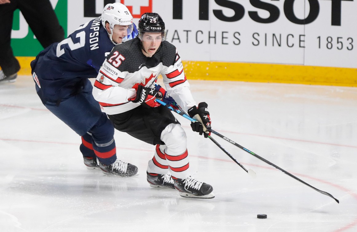 Owen Power challenges for the puck with Tage Thompson