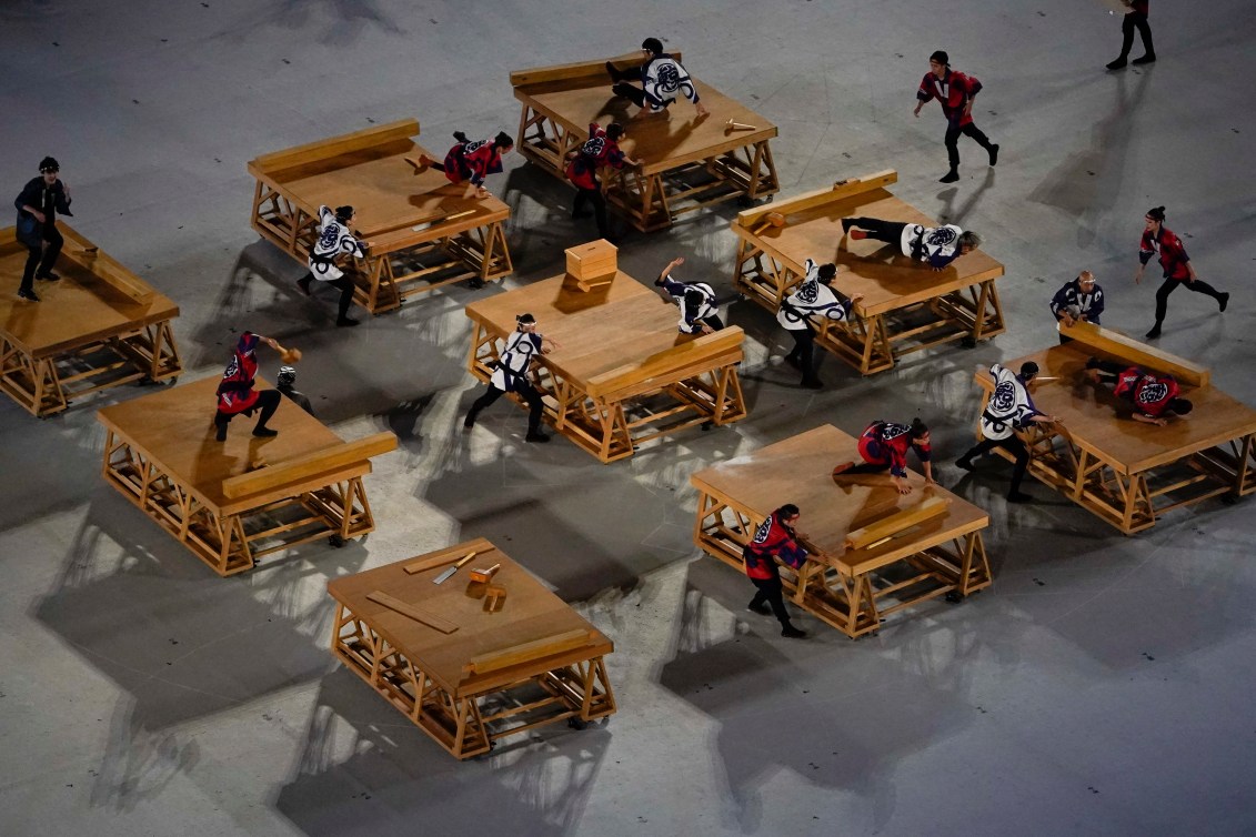 Dancers performing on tables with wooden props.