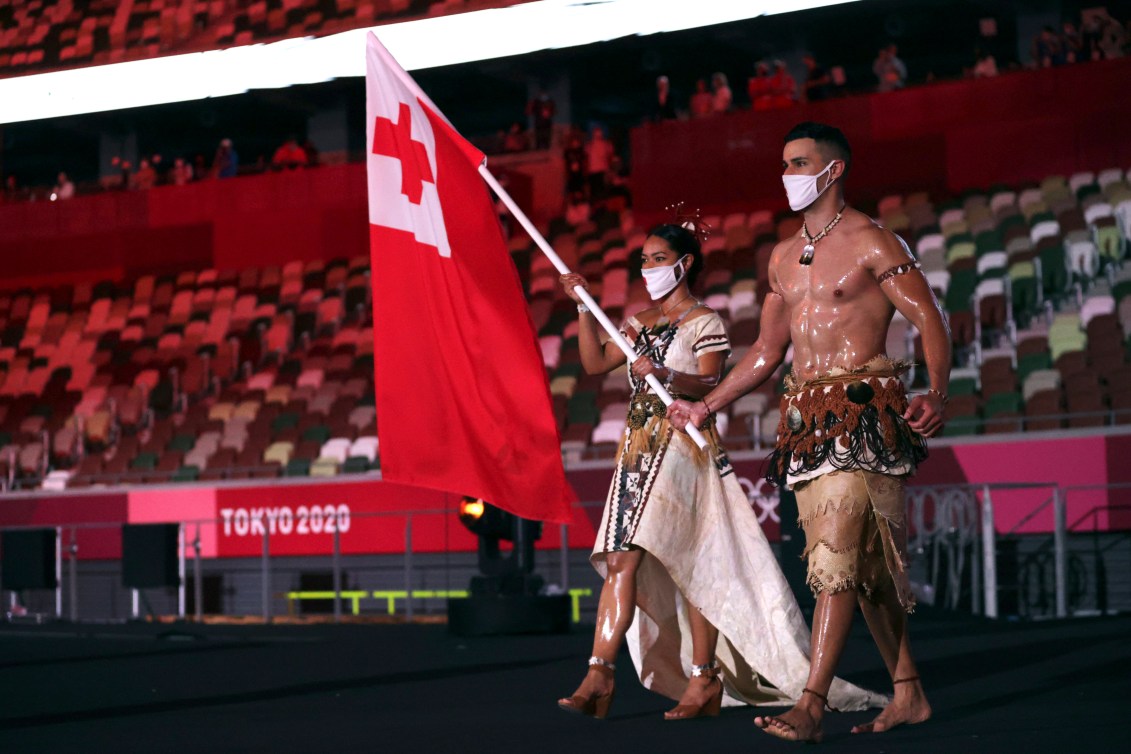 Malia Paseka and Pita Taufatofua carry the Tongan flag in to the Opening Ceremony.