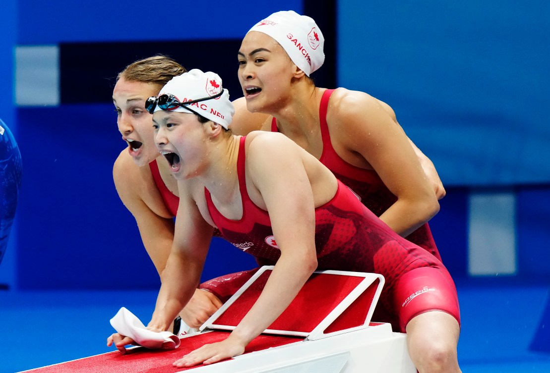 Three Canadian swimmers, Rebecca Smith, Margaret Mac Neil and Kayla Sanchez, shout their encouragement to teammate Penny Oleksiak, not pictured.