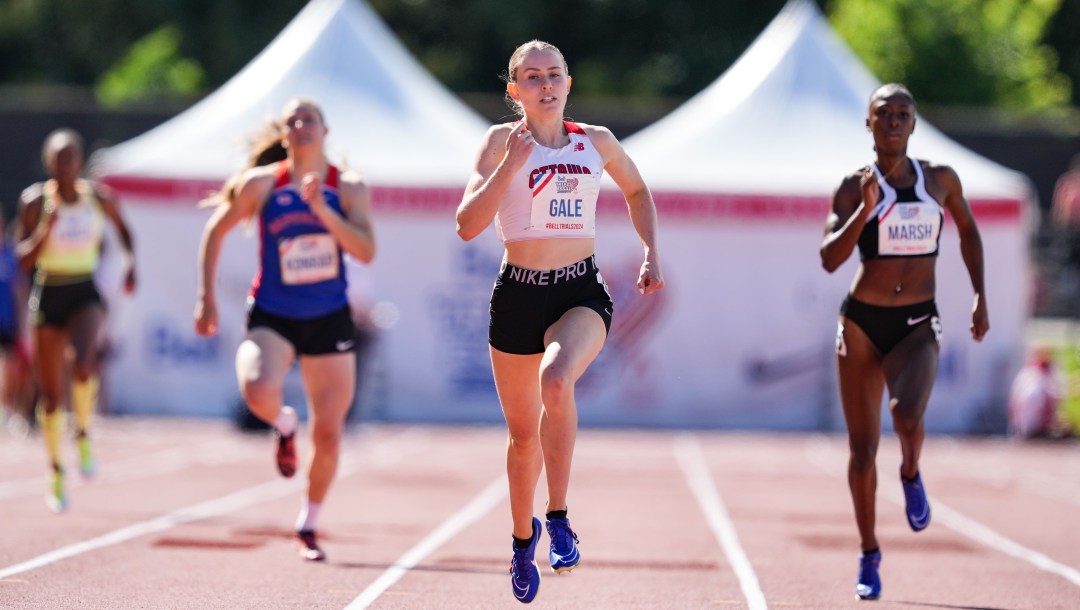 Lauren Gale leads a race while wearing a white singlet and black shorts