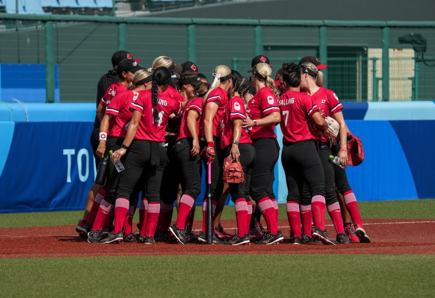 The Canadian women’s softball team in a huddle.