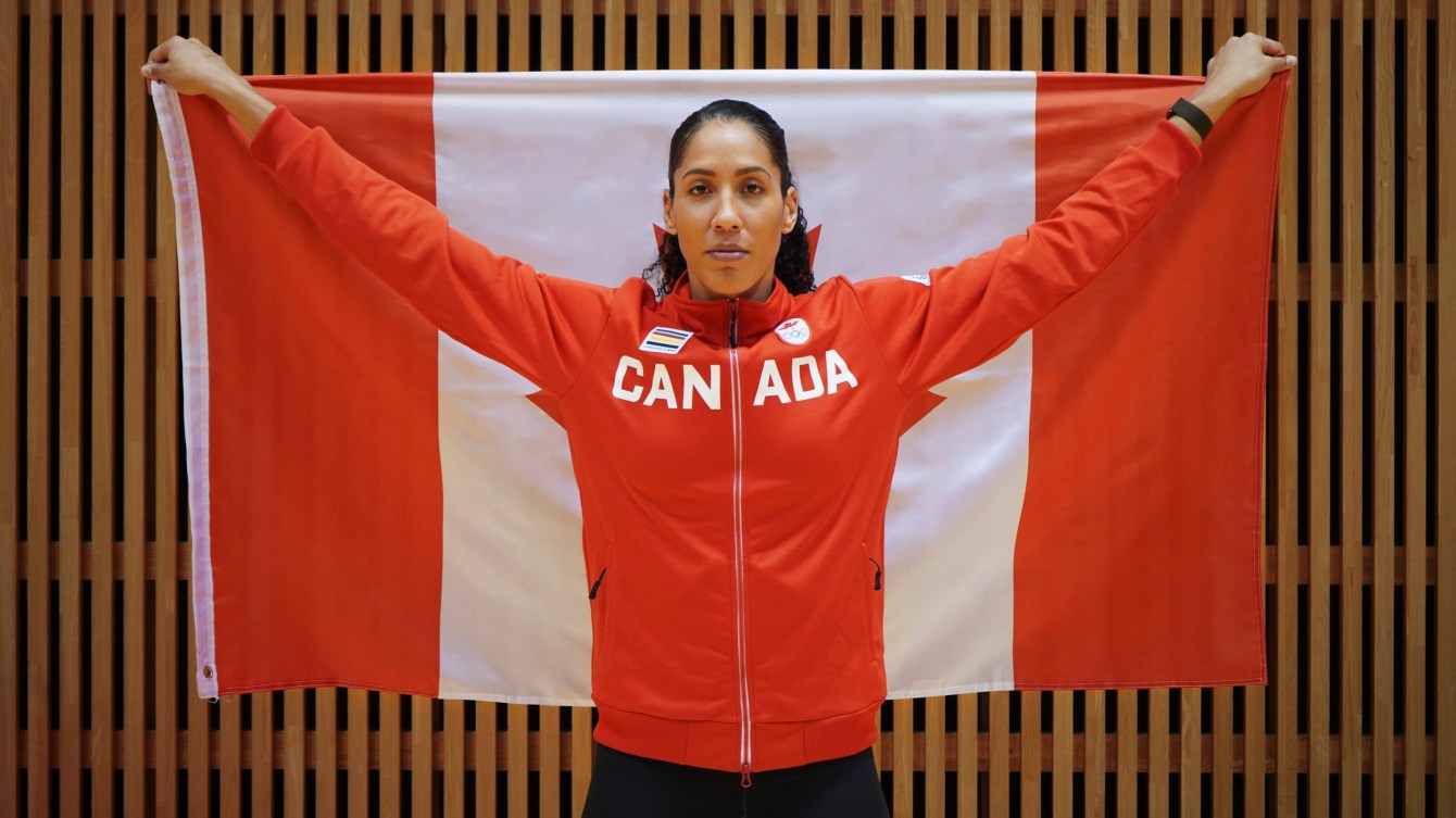 Miranda Ayim holds a Canadian flag behind her