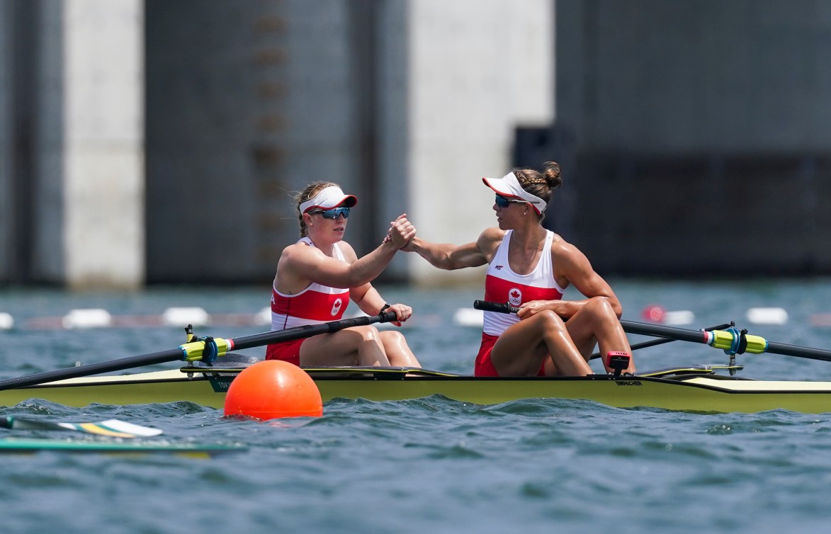 Two rowers shake hands after a race