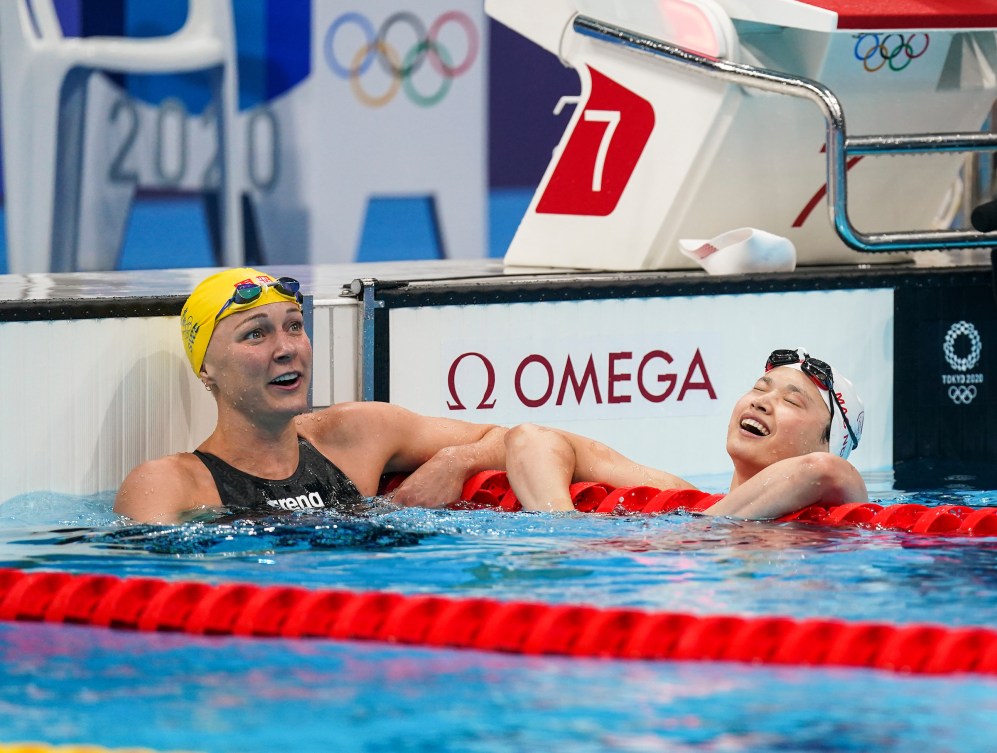 Maggie MacNeil reacts to her victory at the wall with Sarah Sjostrom 