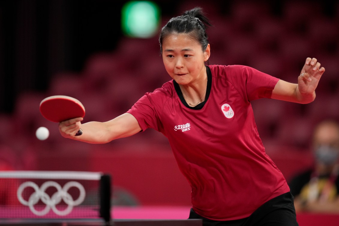 Zhang Mo hits the ball in a table tennis match